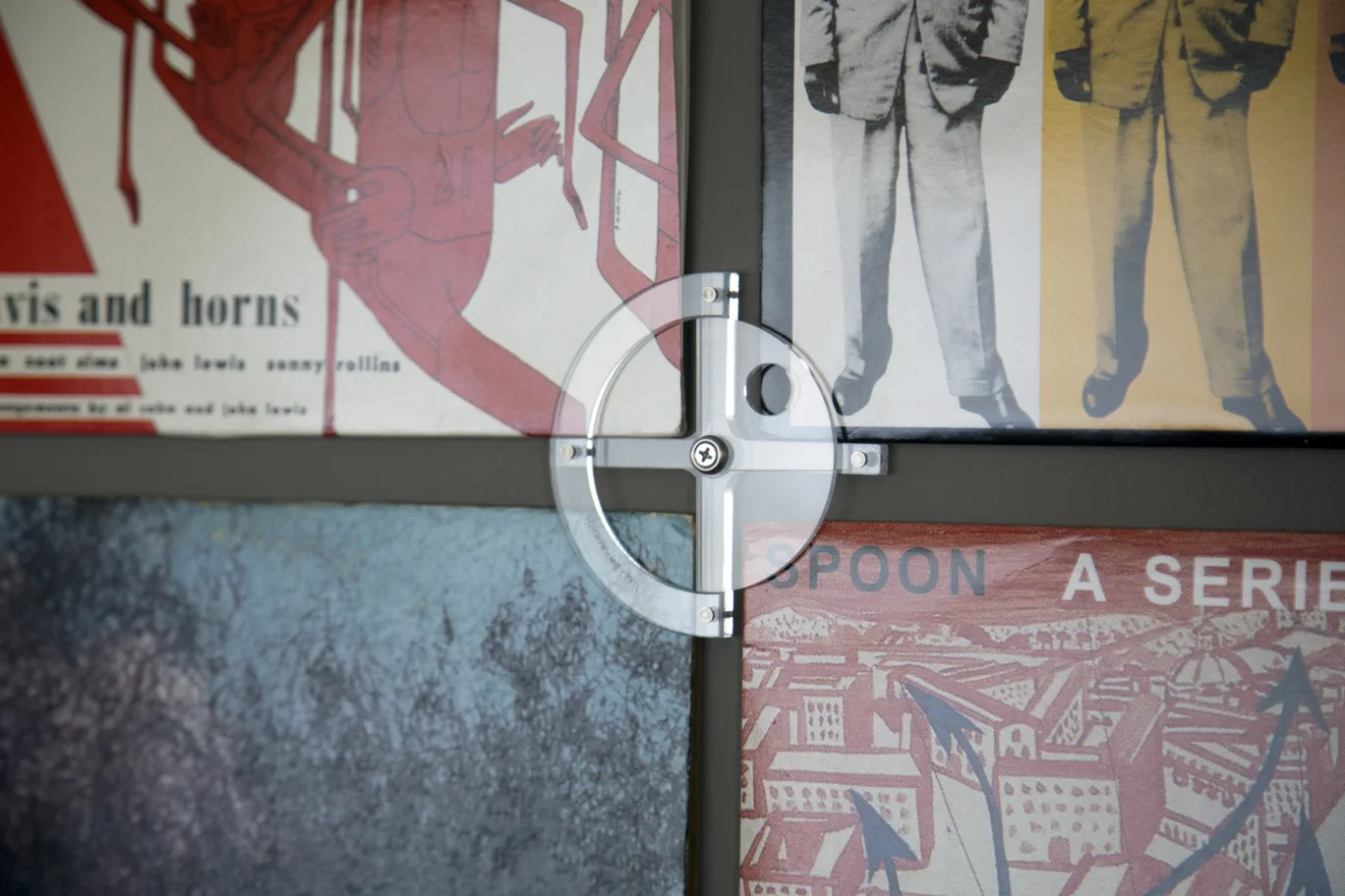 Single Spinmount unit holding four vinyl records on a wall.